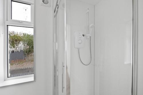 a shower in a bathroom with a window at Stylish Great Location Near Tamar Bridge in Saltash