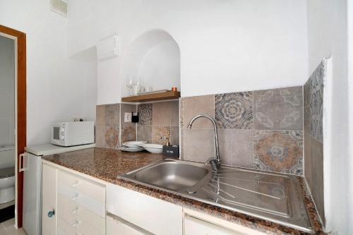 a kitchen with a sink and a microwave at Obispo Rancés 12 A in Chiclana de la Frontera