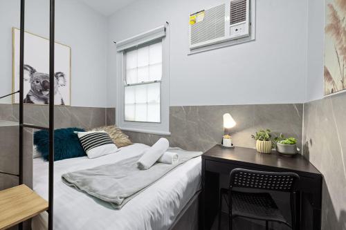 a small bedroom with a bed and a desk at Private Double Bed in Sydney CBD Near Train in Sydney