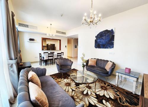 uma sala de estar com um sofá, cadeiras e uma mesa em RH- The Perfect Family Getaway, 3BR in Standpoint Tower no Dubai
