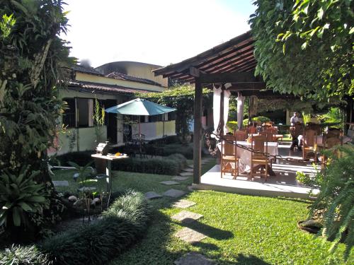a patio with a table and an umbrella in a yard at Pousada Caúca in Abraão