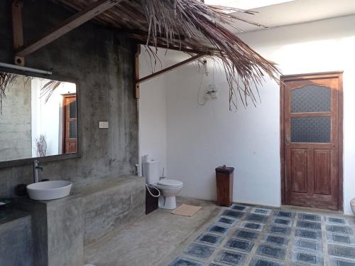 łazienka z toaletą, umywalką i drzwiami w obiekcie CocoVilla Boutique Resort w mieście Beruwala