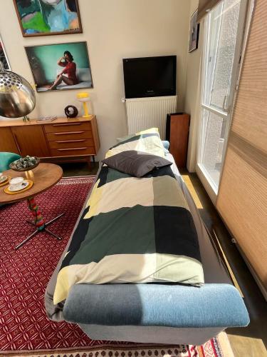 a bedroom with a bed and a table and a television at Ancien Cinema Loft in Vianden