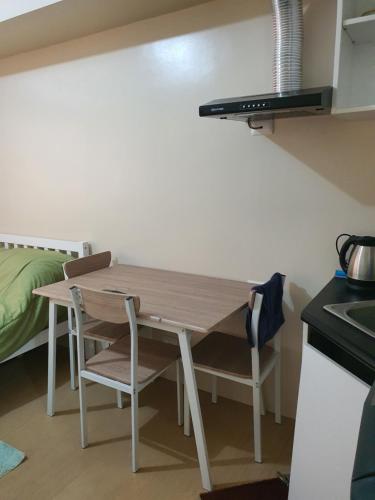 a kitchen with a table and two chairs and a bed at MARIDAN AVIDA CONDO in Iloilo City