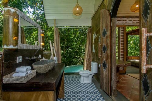 a bathroom with a tub and a sink and a toilet at Sacred Canyon Ubud by Pramana Villas in Payangan