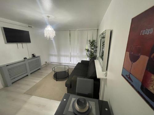 a living room with a couch and a tv at NEW! Xtra Large 4 bedroom Up to 12 guests in Woolwich