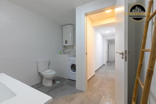 a bathroom with a toilet and a washing machine at Apartamento Camino Lago in Torremolinos