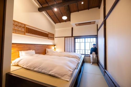 上越的住宿－‐izen 高田‐ 多賀，两张床铺,房间中间有人