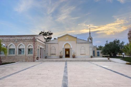 a church with a large driveway in front of it at Borgo Vita Novella Resort in Marzamemi