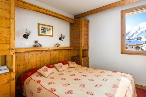 Schlafzimmer mit einem Bett und einem Fenster in der Unterkunft Lagrange Vacances L'Ecrin des Sybelles in La Toussuire