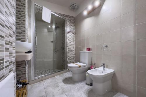 a bathroom with a toilet and a sink and a shower at Borgo Vita Novella Resort in Marzamemi