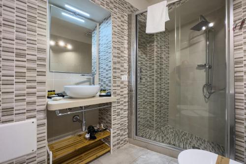 y baño con lavabo y ducha acristalada. en Borgo Vita Novella, en Marzamemi