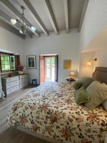 a bedroom with a large bed with a floral bedspread at Casa da Vinha - Quinta dos Pegões in Tomar