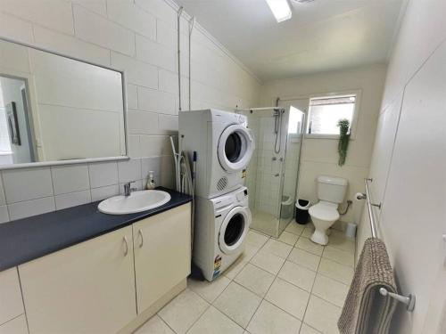 a bathroom with a washing machine and a sink at Three Palms Apartments Unit 1 in Esperance