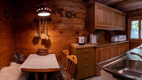 - une cuisine avec une table et un évier dans une cabine dans l'établissement Ferienhütte Puutz, à Wörgl