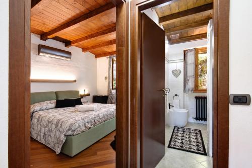 a bedroom with a bed and a bathroom at Farmhouse of Grandfather Chek in Bellagio