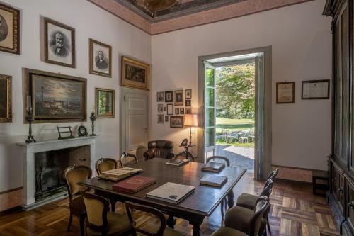 une salle à manger avec une table, des chaises et une cheminée dans l'établissement Villa Galimberti Maison De Charme, à Osnago