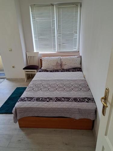 a bed sitting in a room with a window at encanto in Plovdiv