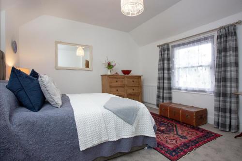 a bedroom with a bed and a window at Raleighs Rest in East Budleigh