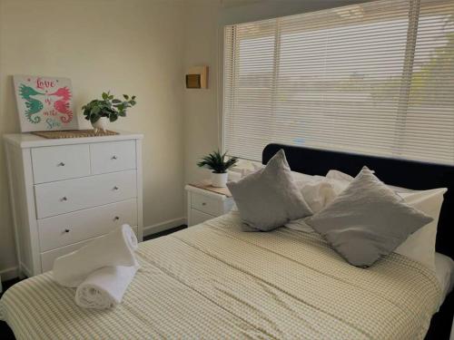 a bedroom with a bed with pillows and a window at Esperance Little Units 2 in Esperance