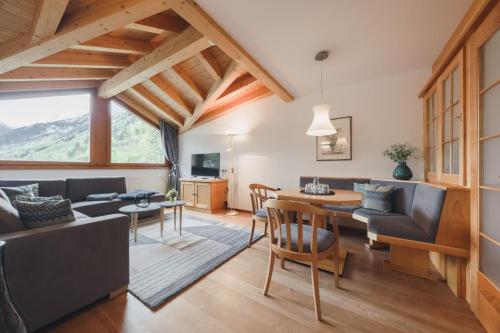 a living room with a couch and a table and chairs at Alpenhotel Montafon & SPA in Schruns