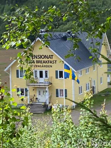 a yellow building with a flag in front of it at Sälengården in Vörderås