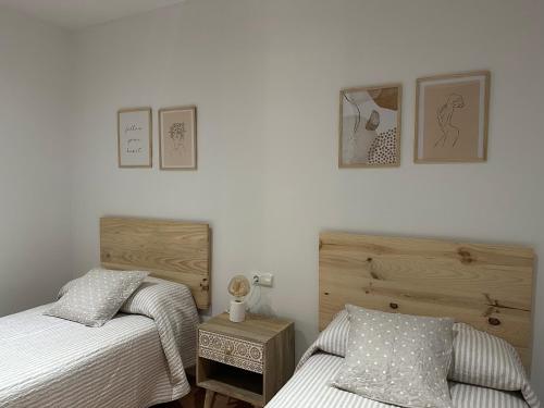 um quarto com 2 camas e uma cómoda em madeira em APARTAMENTOS MAR DE AREAS em Sanxenxo