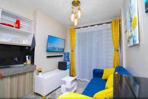 a living room with a blue couch and yellow curtains at Superb Studio Apartment in Nairobi
