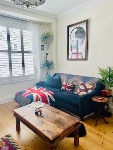 a living room with a blue couch and a coffee table at Grade II boho home in the heart of Oxford St. in Southampton