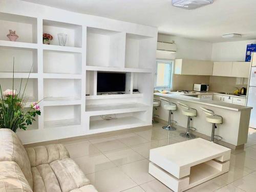 a living room with a couch and a kitchen at Family House in Natanya in Netanya