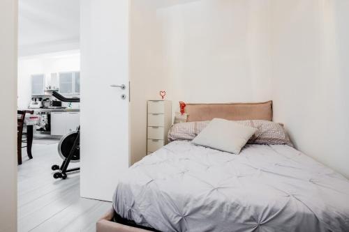 Un dormitorio con una cama y una pared blanca. en Casa la coccinella, en Orbetello