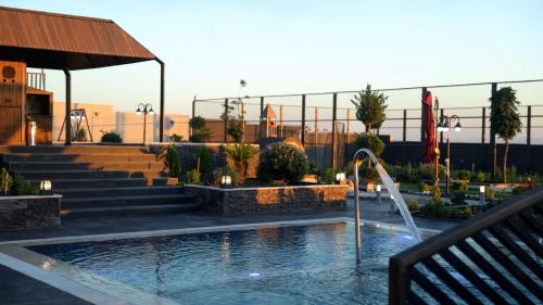 a swimming pool with a fountain in a building at Kinda vip in Al Mashāriqah