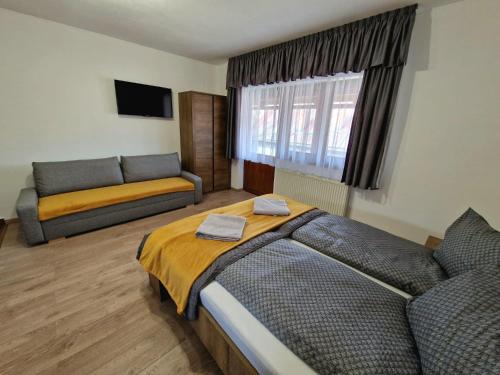 a living room with a bed and a couch at Kodaros Studio Parajd in Praid
