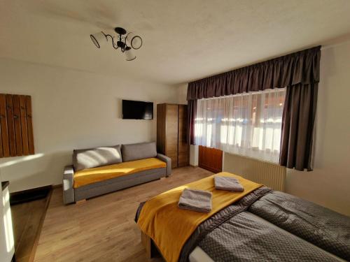 une chambre d'hôtel avec un lit et un canapé dans l'établissement Kodaros Studio Parajd, à Praid