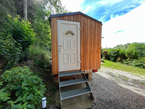 a tiny house with a door on a ladder at Tiny house Horní Planá in Horní Planá