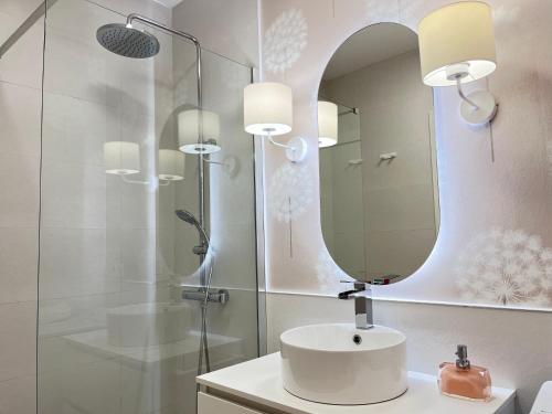 La salle de bains est pourvue d'un lavabo et d'un miroir. dans l'établissement COQUETO APARTAMENTO, à Torrelavega