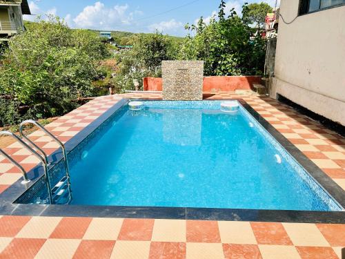 a swimming pool with a tiled floor at Hotel Lake Paradise Mahabaleshwar in Mahabaleshwar