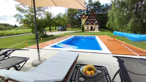 Macanovići的住宿－Apartman Brezuljak Banja Luka Cokorska polja，一个带桌子和遮阳伞的游泳池
