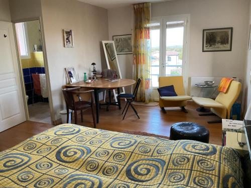 1 dormitorio con 1 cama, mesa y sillas en Maison Bon Ton, en Paraza