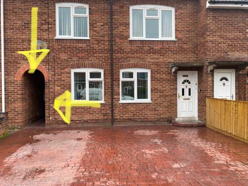 a brick building with yellow arrows painted on it at Lovely 2 bed apartment sleeps 5 in Abingdon