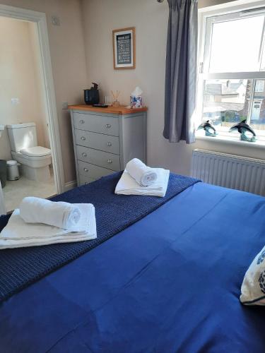 a bedroom with two beds with towels on them at Coddiwomple in Leyburn