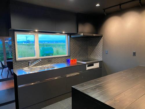 a kitchen with a sink and a window at HOKKAIDO VILLA e2 in Nakafurano