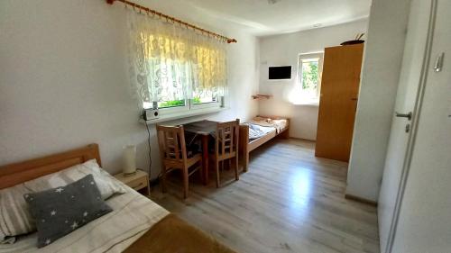 1 dormitorio con cama, mesa y escritorio en Sloneczko1, en Smołdzino