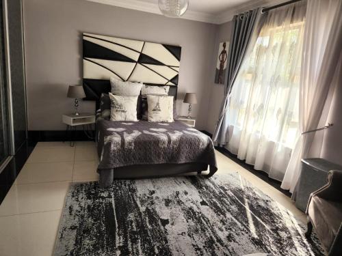 a bedroom with a bed and a large window at Umhlanga Rocks Guesthouse flat in Durban