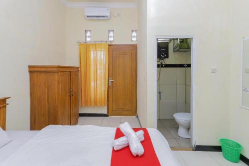 a bedroom with a bed and a shower and a toilet at RedDoorz Syariah near Alun Alun Pasuruan in Pasuruan