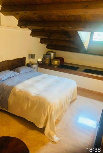 a bedroom with a white bed with a wooden floor at Attico96 Intero appartamento in centro storico in Marostica