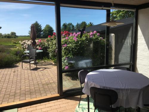 a patio with a table and a view of a garden at Harvey`s Bed & Breakfast in Hjørring