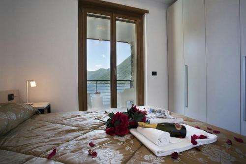 a bedroom with a bed with towels and flowers on it at Residence degli Oleandri 6A in Argegno