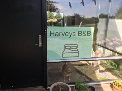a sign on the door of a house with a dog in the window at Harvey`s Bed & Breakfast in Hjørring