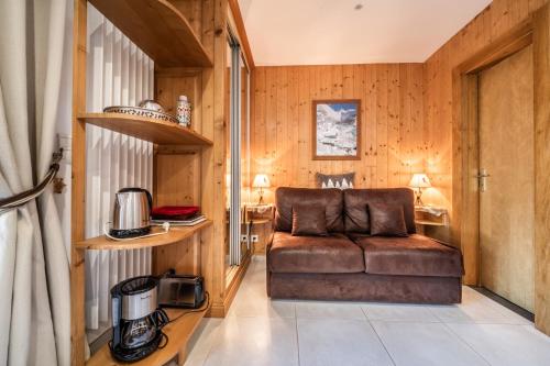 - un salon doté d'un canapé brun dans l'établissement Au Rêve Savoyard 1 - 2 personnes, à Morillon